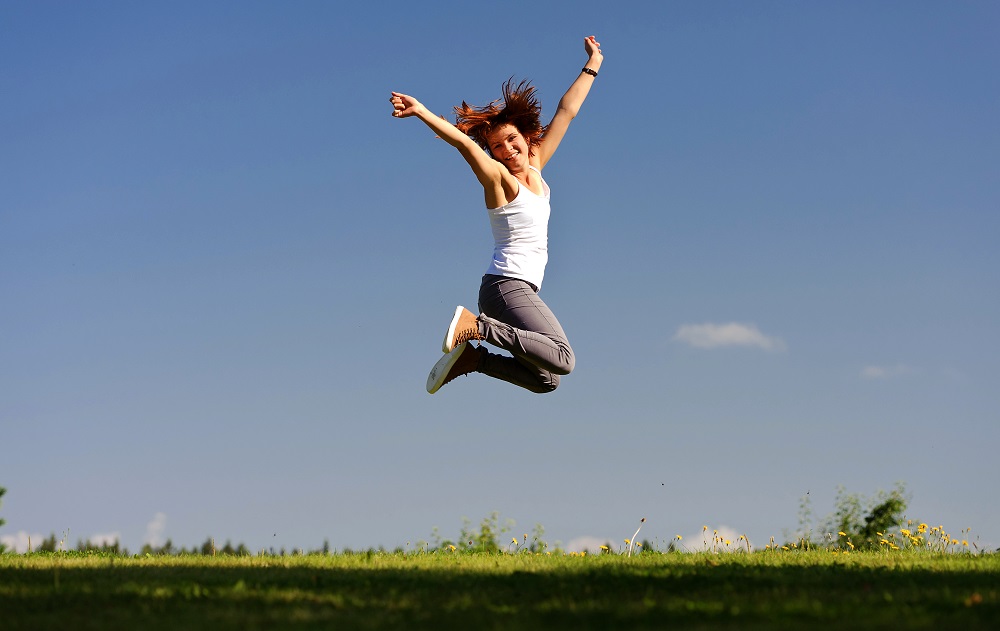 Energievolle-Frau-mit-ausreichender-Versorgung-mit-Vitaminen-springt-in-die-Luft