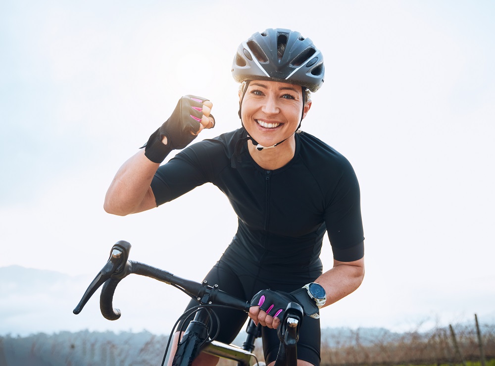 Sportliche-Frau-am-Fahrrad-freut-sich-ueber-ihren-Erfolg
