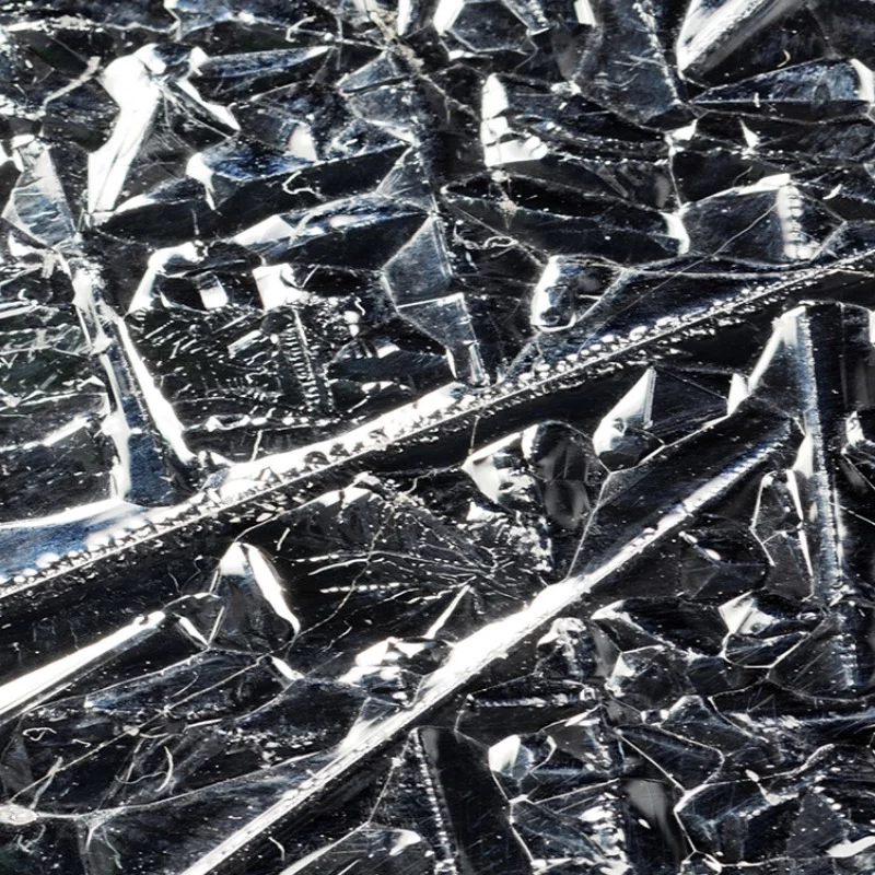 Nahaufnahme einer zerknitterten und reflektierenden Silberfolie, die scharfe Falten, Linien und strukturierte Oberflächen mit hellen und dunklen Bereichen zeigt, die ihre metallische Qualität hervorheben.