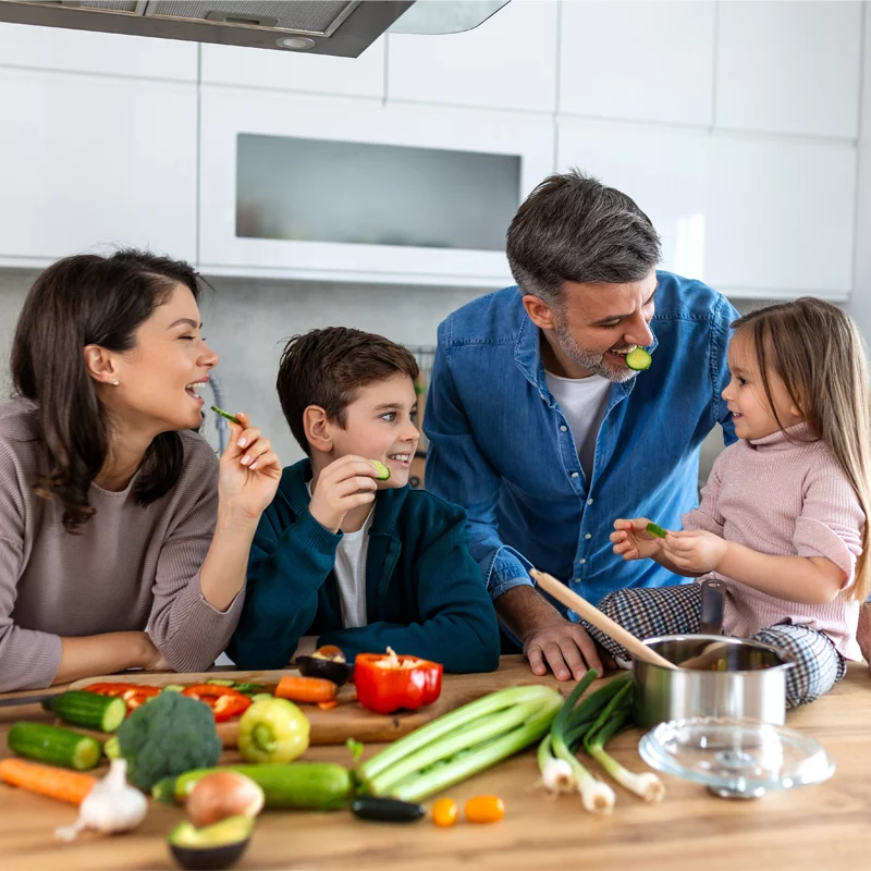 Familie mit kleinen Kindern in der Küche mit Lebensmitteln mit vielen Nährstoffen